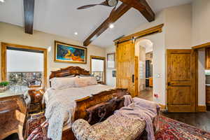 Bedroom with vaulted ceiling with beams, dark wood-style floors, a barn door, a ceiling fan, and recessed lighting