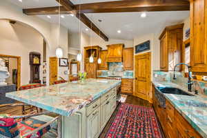 Dual tone kitchen featuring two tone cabinetry, a kitchen bar, tasteful backsplash, hanging light fixtures, and lofted ceiling