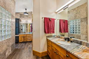Full bath with two vanities and dark wood finished floors
