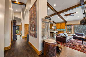 Living room featuring dark wood-style flooring, lofted ceiling with beams, recessed lighting, ceiling fan, and plenty of natural light