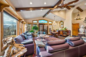 Living area featuring wood finished floors, hanging lights, and french doors