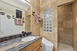 Full bathroom featuring vanity, a walk in shower, and tile walls