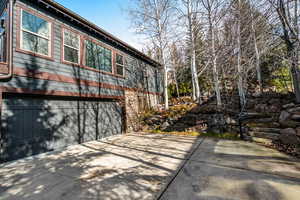 View of property exterior featuring a garage and driveway