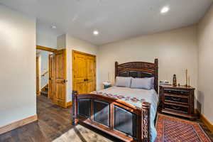 Bedroom with a closet, dark wood finished floors, and recessed lighting
