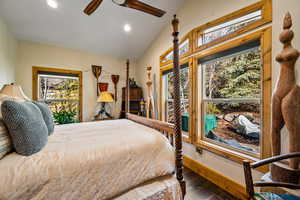 Bedroom with lofted ceiling, dark wood-style flooring, ceiling fan, and recessed lighting