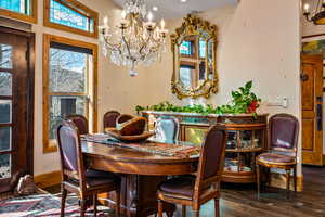 Dining space with a chandelier, wood finished floors, and plenty of natural light