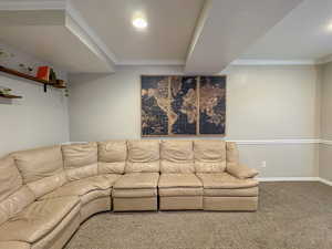 Living area with crown molding and carpet