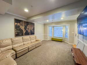 Living room with ornamental molding, recessed lighting, and carpet floors