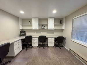 Office featuring a baseboard heating unit, built in desk, and recessed lighting