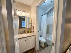 Bathroom featuring vanity, a textured ceiling, and shower / bath combo with shower curtain