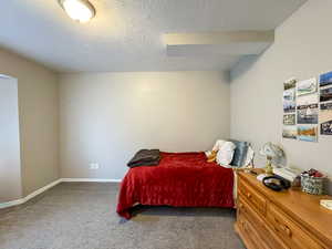 Bedroom with a textured ceiling and carpet flooring
