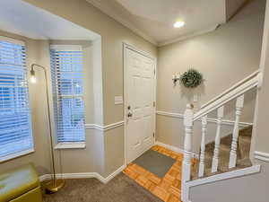 Foyer entrance featuring crown molding and parquet floors