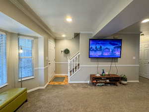 Foyer entrance with crown molding, a textured ceiling, carpet floors, and recessed lighting