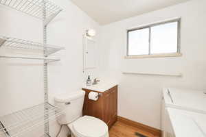 Bathroom featuring vanity, light wood-style flooring, and separate washer and dryer