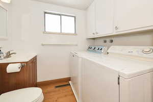 Laundry area featuring light wood-style flooring and washing machine and dryer