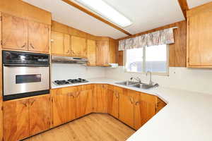 Kitchen featuring stainless steel appliances, light countertops, light wood-style floors, and wood finish cabinets
