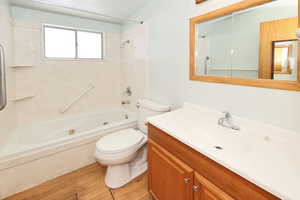 Bathroom featuring vanity, bathtub / shower combination, and light wood-type flooring