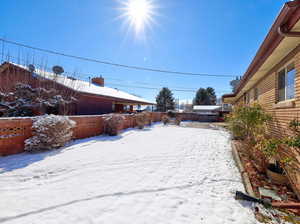 Yard covered in snow with a fenced backyard