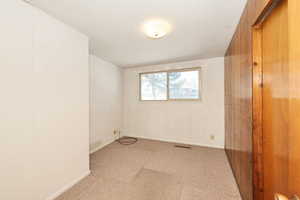 Carpeted spare room with baseboards