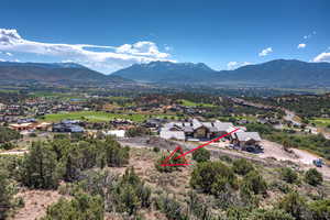 Drone / aerial view of a mountain backdrop and a local golf course