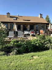 Back of property with a chimney, an outdoor hangout area, a patio, and stucco siding