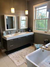 Bathroom featuring double vanity and a soaking tub