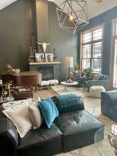 Living room featuring vaulted ceiling, a glass covered fireplace, and wood finished floors