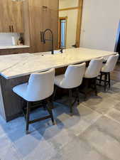 Kitchen featuring a breakfast bar, light stone counters, and modern cabinets