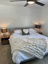 Carpeted bedroom featuring ceiling fan