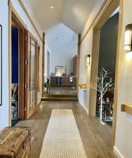 Hallway featuring lofted ceiling, wood-type flooring, and wine cooler