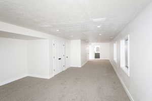 Basement featuring carpet floors, recessed lighting, and a textured ceiling