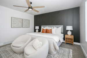 Bedroom featuring ceiling fan, carpet flooring, and an accent wall