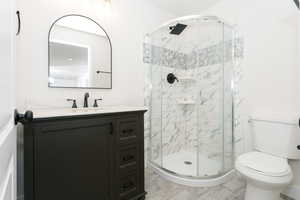Full bathroom with vanity and a shower stall