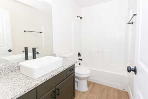 Bathroom featuring vanity, light wood-type flooring, and shower / bathtub combination
