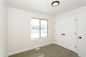 Unfurnished bedroom featuring carpet and a closet