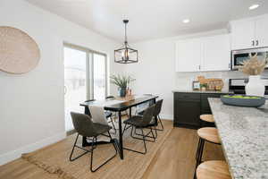 Dining area featuring light wood-style floors and hanging lights