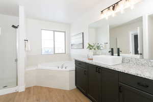 Bathroom with vanity, light wood-type flooring, a shower stall, and a garden tub