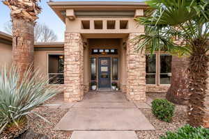 View of exterior entry featuring stucco siding and stone siding