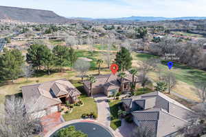 Aerial view of residential area featuring a golf course and a mountain backdrop