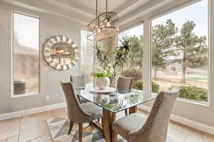 Dining room with suspended lighting and light tile patterned flooring