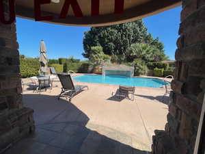 View of swimming pool with patio surround and a fenced backyard