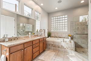 Full bath featuring a stall shower, double vanity, a bath, recessed lighting, and light tile patterned flooring