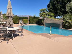 Community pool with a patio and a mountain view