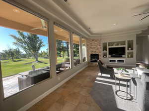 Sunroom / solarium featuring stone tile floors and golf course view