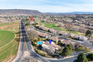 Aerial perspective of suburban area with a mountain backdrop and a golf club
