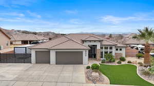 View of front of house with a garage, stucco siding, driveway, a tiled roof, and stone siding