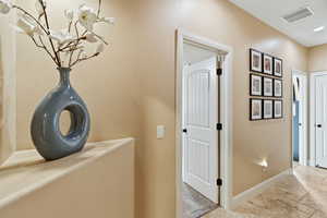 Corridor featuring stone tile flooring and baseboards