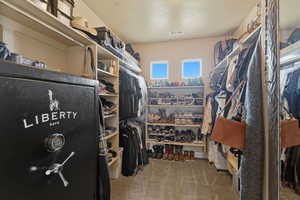 Walk in closet featuring light colored carpet