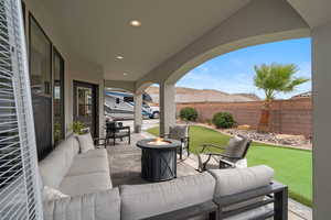 Fenced backyard featuring an outdoor living space with a fire pit and a patio