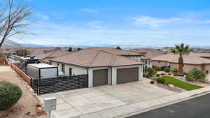 View of front of property with an attached garage, a residential view, driveway, and stucco siding